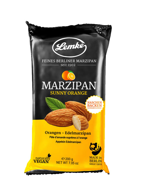 Eine Packung Lemke Sunny Orange Marzipan (200g). Die Verpackung hebt hervor, dass es sich um feines Berliner Orangen-Edelmarzipan handelt, natŸrlich vegan ist und in Berlin hergestellt wird. Es eignet sich zum Naschen, Backen und Dekorieren.