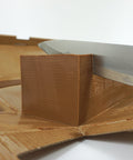 Ein Block dunkles Haselnussnougat, der mit einem Messer präzise geschnitten wird. Perfekt für Konditoren und Schokoladenliebhaber, ideal für die Zubereitung von Pralinen und Desserts. Hochwertige Qualität von Lemke.